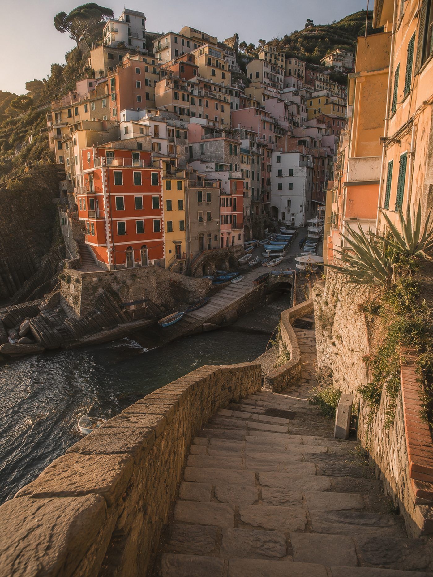 Blick durch die enge Schlucht von Riomaggiore, in der sich die bunten Häuser terrassenförmig bis zum Meer hinunterstaffeln